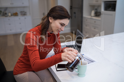 Beautiful woman pouring black coffee in mug