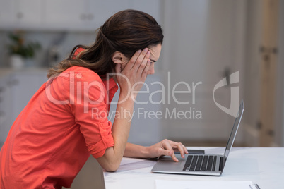 Tensed woman working on laptop