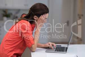 Tensed woman working on laptop