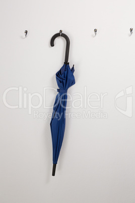 Blue umbrella hanging on hook