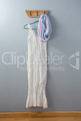 White dress and scarf hanging on hook