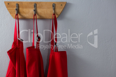Red aprons hanging on hook