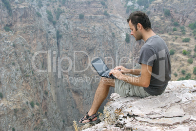 sitting on rock and using laptop, I live on my laptop as I travel, using it to write, work, stay in touch with family and friends