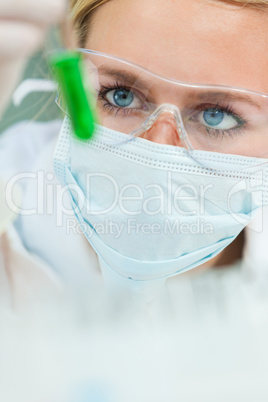 Female Scientist With Green Test Tube In Laboratory