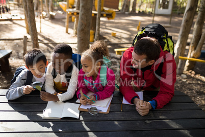 Teacher assisting kids in studying