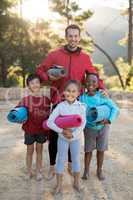 Portrait of coach and kids standing with yoga mat