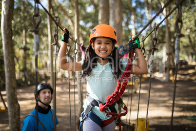 Portrait of cute girl crossing zip line