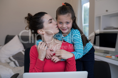 Affectionate mother kissing daughter