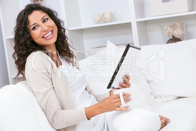 Woman Laughing Drinking Tea or Coffee Using Tablet Computer