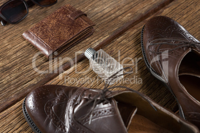 Shoes, perfume, wallet and sunglasses on wooden plank
