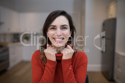 Happy woman sitting in kitchen