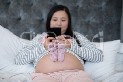 Pair of baby socks on pregnant woman stomach