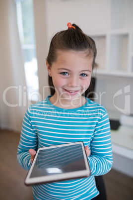 Cute girl holding digital tablet in home