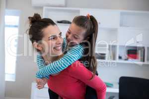 Mother giving piggyback to daughter