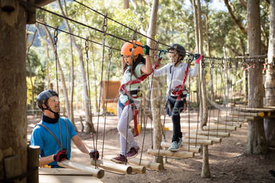 Instructor assisting kid in zip line