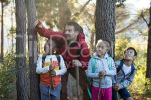 Teacher pointing at distant in forest