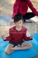 Overhead of boy meditating in park