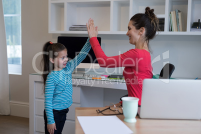 Mother and daughter giving high five to each other