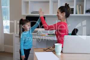 Mother and daughter giving high five to each other