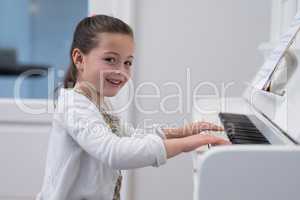 Portrait of cute girl playing piano