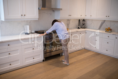 Worried woman standing in kitchen