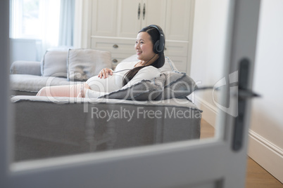 Pregnant woman listening music on headphones