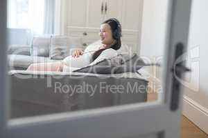 Pregnant woman listening music on headphones