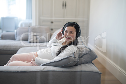 Pregnant woman listening music on headphones