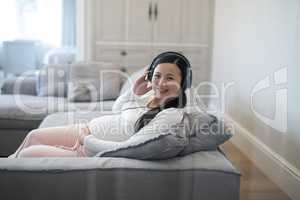 Pregnant woman listening music on headphones