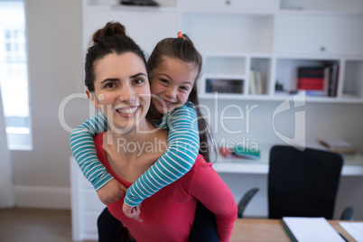 Portrait of mother giving piggyback to daughter