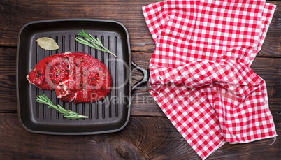 raw beef with spices in a square black frying pan