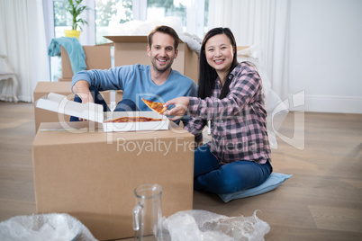 Couple having pizza at their new home