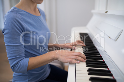 Mid section woman playing piano