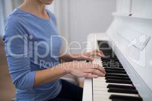 Mid section woman playing piano