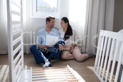 Couple holding document while interacting with each other