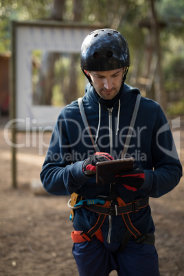 Instructor in protective workwear using digital tablet