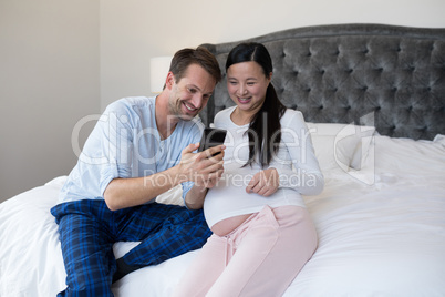 Happy couple reviewing picture on mobile phone