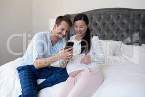 Happy couple reviewing picture on mobile phone