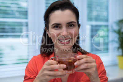 Woman having lemon tea in kitchen