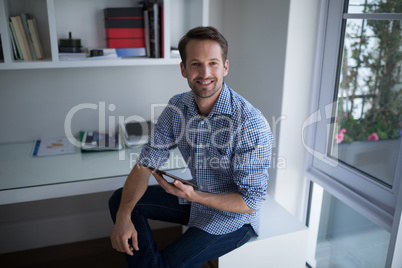 Portrait of man holding digital tablet