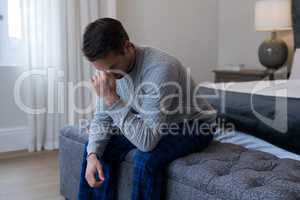 Tensed man sitting on bed