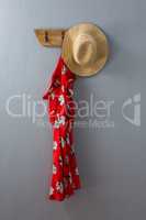 Red dress and hat hanging on hook