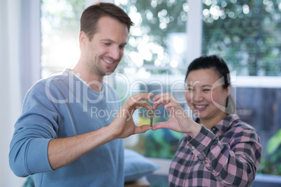 Smiling couple making heart shape with hands