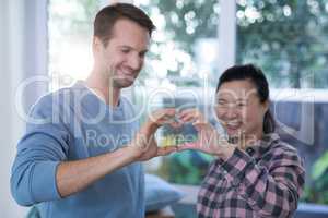 Smiling couple making heart shape with hands