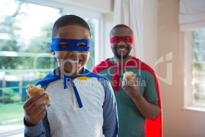 Father and son having muffin at home