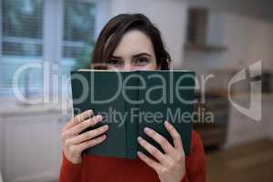 Beautiful woman covering her face with book