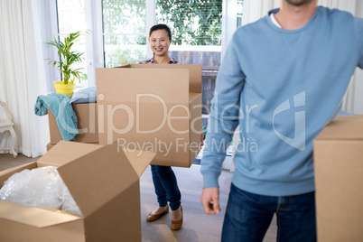 Couple carrying big cardboard box at new home