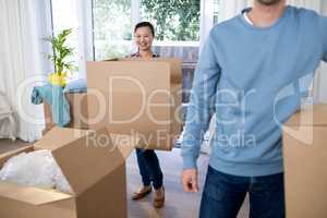 Couple carrying big cardboard box at new home