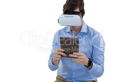 Male executive using virtual reality headset and digital tablet