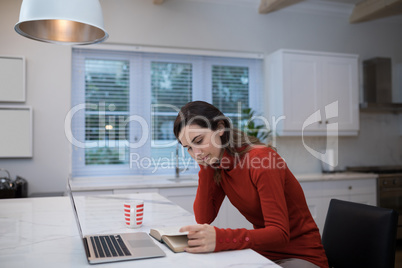 Woman reading novel at table